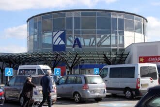 Indgangen til Kolding Storcenter med biler på parkeringspladsen