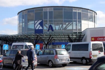 Indgangen til Kolding Storcenter med biler på parkeringspladsen