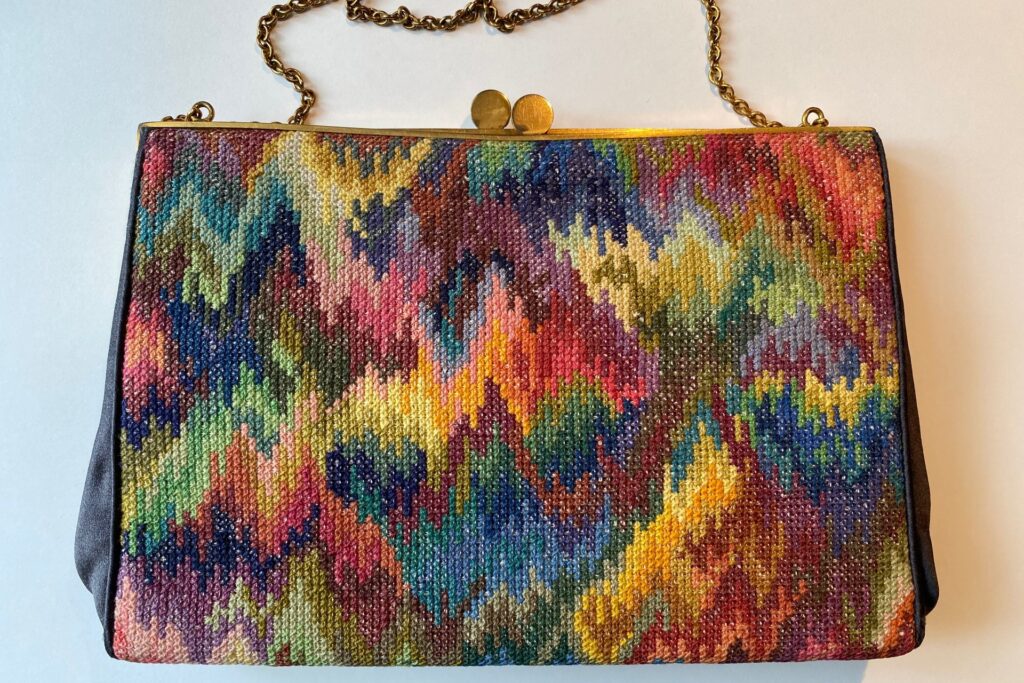 Broderet selskabstaske fra 1960 syet af Dronning Margrethe som barn. Farverig taske med bargello-mønster i gule, røde, blå og grønne nuancer - begyndelsen på Dronningens livslange passion for broderi.