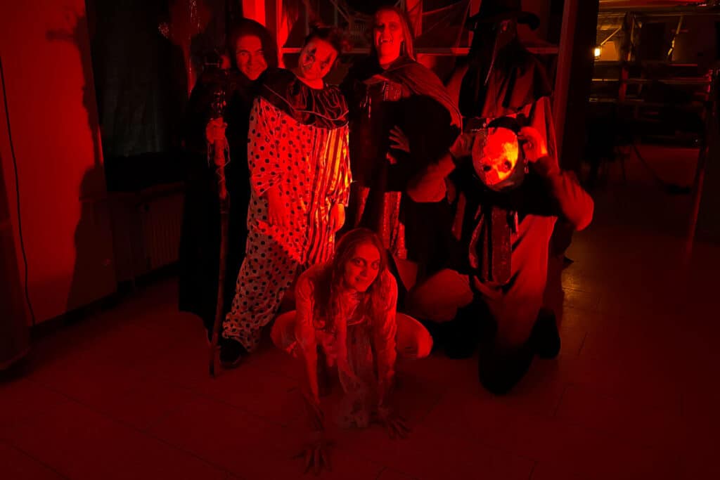 Udklædte skuespillere fra Haunted House i BY-LAB i Kolding med Halloween-kostumer som klovn og pestdoktor i rødt lys