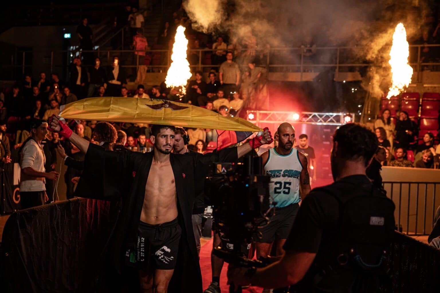 MMA-fighter gør entré med flag og flammer under MMA Galla show i arena