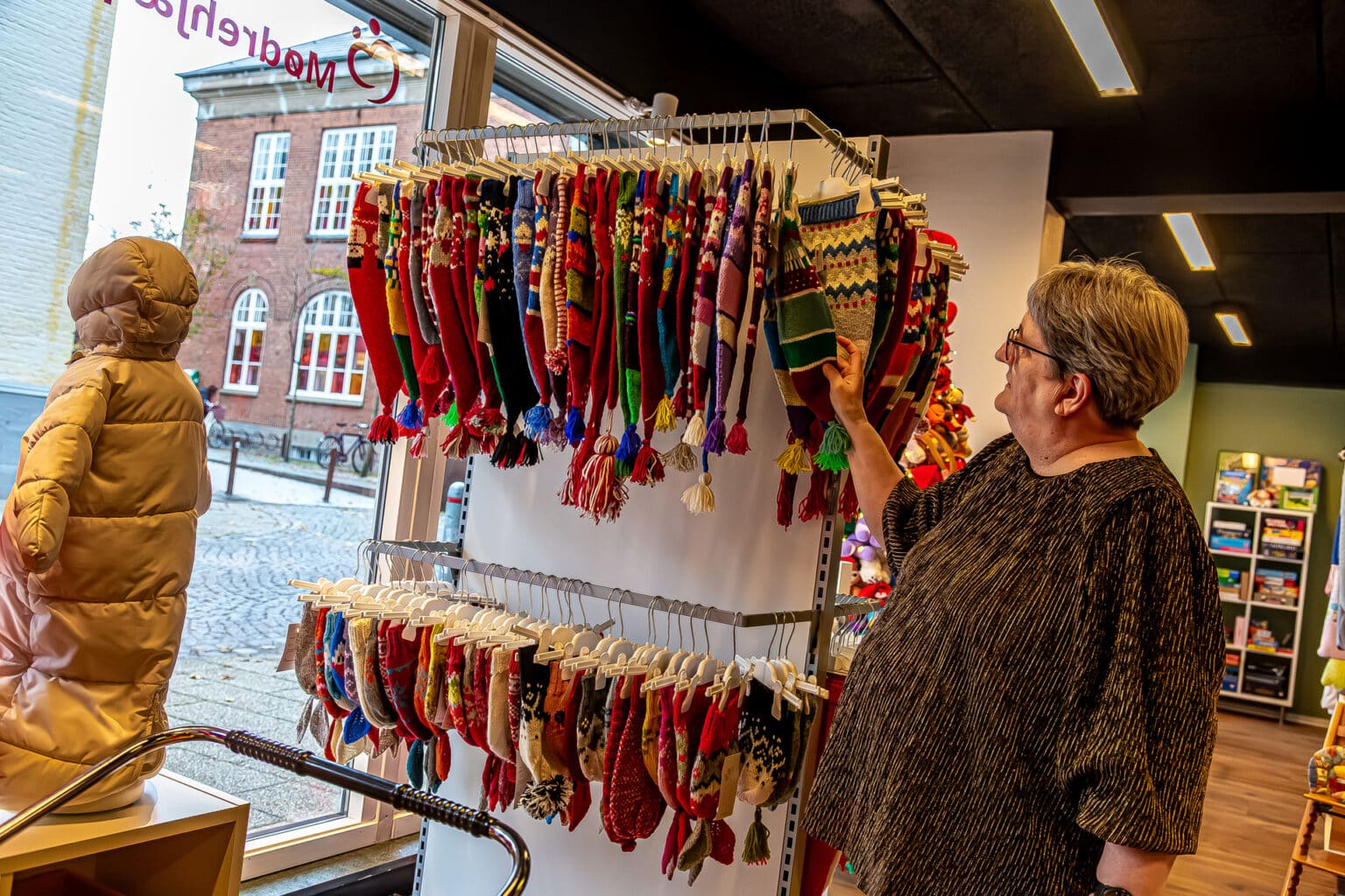 Birgit Christensen ved stativ med nissehuer hos Mødrehjælpen i Kolding